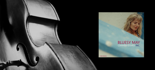 Banner featuring the album cover of “Bluesy May – Live” by Carmen Gomes Inc. The cover shows a moody, atmospheric design that reflects the album’s blend of blues and jazz emotion. A “Shop Now” button appears beside the image, inviting visitors to purchase or explore the album. The overall tone of the banner is warm and intimate, echoing the live recording’s authentic sound and emotional depth.
